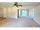 Large living room with neutral walls and carpeting and views into the entry, dining area, and backyard at 5096 The Oaks Cir, Orlando, FL 32809