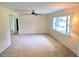 Spacious living room with a large window that provides natural light, neutral walls, and a ceiling fan at 5096 The Oaks Cir, Orlando, FL 32809