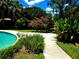 A serene pool area surrounded by lush tropical foliage offers the perfect spot for relaxation at 5096 The Oaks Cir, Orlando, FL 32809
