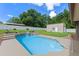 Beautiful backyard features a lush, green lawn, storage shed, and sparkling in-ground pool at 51 Seminole Dr, Debary, FL 32713