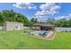 Expansive backyard with manicured lawn, storage shed, privacy fence, and sparkling in-ground pool at 51 Seminole Dr, Debary, FL 32713