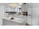 Well-lit kitchen features white cabinets, a mosaic backsplash, an island, and modern appliances at 51 Seminole Dr, Debary, FL 32713