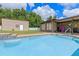 Sparkling in-ground pool with tile trim is adjacent to covered patio and storage shed in backyard at 51 Seminole Dr, Debary, FL 32713