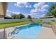 Sparkling in-ground pool with tiled trim and concrete patio is surrounded by a lush, green lawn at 51 Seminole Dr, Debary, FL 32713