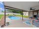 Covered patio with ceiling fan looks out onto a sparkling in-ground pool surrounded by manicured lawn at 51 Seminole Dr, Debary, FL 32713
