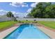 Sparkling in-ground pool with tiled trim is surrounded by a concrete patio and well-maintained lawn at 51 Seminole Dr, Debary, FL 32713