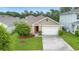 Aerial view of a beige single-Gathering home with a well-kept lawn and a driveway at 522 Anne St, Deland, FL 32724