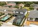 Aerial view of home featuring an enclosed pool, manicured yard, and brick driveway at 7454 Gathering Dr, Reunion, FL 34747