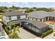 Aerial view of a two-story home with an enclosed pool and brick driveway at 7454 Gathering Dr, Reunion, FL 34747