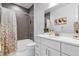 Bathroom featuring modern vanity with marble countertop and gray tiled shower-tub combination at 7454 Gathering Dr, Reunion, FL 34747