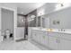 Modern bathroom featuring a glass-enclosed shower, double vanity, and tile flooring at 7454 Gathering Dr, Reunion, FL 34747