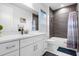 Modern bathroom showcasing a stylish vanity, large mirror, and shower-tub combination with gray tile surround at 7454 Gathering Dr, Reunion, FL 34747