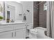 Bright bathroom features a white vanity, white toilet, and tub with gray tile surround at 7454 Gathering Dr, Reunion, FL 34747