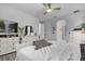 Spacious bedroom with white furniture, ceiling fan, and view to hallway and bathroom at 7454 Gathering Dr, Reunion, FL 34747