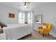 Sunlit bedroom featuring a bright yellow chair, neutral decor, and ample natural light at 7454 Gathering Dr, Reunion, FL 34747