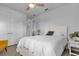 Cozy bedroom with white bedding, ceiling fan, wood floors, and a double door closet at 7454 Gathering Dr, Reunion, FL 34747