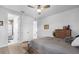 Bright bedroom features a ceiling fan, light hardwood floors, and ensuite bathroom access at 7454 Gathering Dr, Reunion, FL 34747