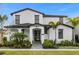 Stunning two-story home with a well-manicured lawn, mature landscaping, and a striking black-and-white design at 7454 Gathering Dr, Reunion, FL 34747