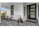 Charming front porch featuring comfortable seating, stylish decor, and a welcoming entrance with modern door at 7454 Gathering Dr, Reunion, FL 34747