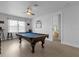 Spacious game room with a pool table, ceiling fan, and natural light from a window at 7454 Gathering Dr, Reunion, FL 34747