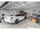 A well-lit two-car garage features a white car and storage space at 7454 Gathering Dr, Reunion, FL 34747