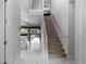 Hallway with staircase, tile flooring, and view into the kitchen and outdoor pool area at 7454 Gathering Dr, Reunion, FL 34747