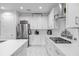 Modern white kitchen featuring stainless steel appliances, quartz countertops and plenty of storage space at 7454 Gathering Dr, Reunion, FL 34747