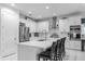 Well-appointed white kitchen featuring stainless steel appliances, quartz countertops and an island with breakfast bar at 7454 Gathering Dr, Reunion, FL 34747