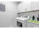 Bright laundry room with a washer, dryer, cabinets, and countertop space at 7454 Gathering Dr, Reunion, FL 34747