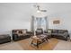 Bright living room with neutral furnishings, ceiling fan, and natural light from large windows at 7454 Gathering Dr, Reunion, FL 34747