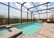 Enclosed pool with spa, waterfall feature, brick patio, and lounge chairs at 7454 Gathering Dr, Reunion, FL 34747