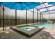 Enclosed pool and spa area with an umbrella and brick patio at 7454 Gathering Dr, Reunion, FL 34747