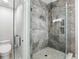 Beautiful primary bath with decorative stone shower and glass door, tiled floors, and modern toilet at 7819 Canyon Lake Cir, Orlando, FL 32835