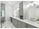 Bright bathroom features dual sinks, white marble floors, vanity storage, and glass enclosed shower at 7819 Canyon Lake Cir, Orlando, FL 32835