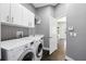 A laundry room with a washer, dryer, cabinets and a built-in sink at 7819 Canyon Lake Cir, Orlando, FL 32835