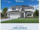 Two-story home featuring white stucco, a two-car garage, and beautifully landscaped yard at 8062 Timberwood Ln, Alafaya, FL 32825