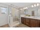 Modern bathroom with a glass shower, double sink vanity, and wood-like flooring at 8484 Sperry St, Orlando, FL 32827