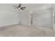 Carpeted bedroom featuring a ceiling fan and a door leading to another room at 8484 Sperry St, Orlando, FL 32827