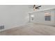 Spacious carpeted bedroom with ceiling fan and large windows overlooking the neighborhood at 8484 Sperry St, Orlando, FL 32827