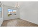 Well-lit dining area with hardwood floors, large windows, and a contemporary chandelier at 8484 Sperry St, Orlando, FL 32827