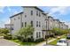 Corner lot featuring a modern townhouse with well-maintained lawn and professionally landscaped front yard at 8484 Sperry St, Orlando, FL 32827