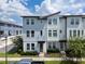 Stylish townhome featuring light-colored siding, modern architectural details, and a manicured lawn at 8484 Sperry St, Orlando, FL 32827