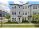 Attractive townhouse featuring a modern facade, well-maintained lawn, and professionally landscaped front yard at 8484 Sperry St, Orlando, FL 32827