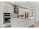 Stylish kitchen featuring white cabinets, quartz countertops, stainless steel appliances, and island with seating at 8484 Sperry St, Orlando, FL 32827