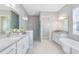 Bright bathroom with a glass-enclosed shower, double vanity sinks, and a soaking tub at 977 Talon Pl, Winter Springs, FL 32708