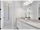 Bright bathroom featuring double sinks, white cabinets, stylish fixtures, and a tub with tiled walls at 977 Talon Pl, Winter Springs, FL 32708