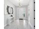 Bright foyer with gray walls, gray floors, console table with decor, and a striking light fixture highlighting the airy space at 977 Talon Pl, Winter Springs, FL 32708