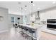 Modern kitchen with a large island, white cabinets, pendant lights, stainless steel appliances, and an adjacent dining area at 977 Talon Pl, Winter Springs, FL 32708