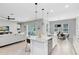 Open layout featuring a kitchen island and stainless steel appliances, seamlessly flowing into the living and dining areas at 977 Talon Pl, Winter Springs, FL 32708