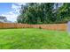 Expansive backyard with a lush green lawn, enclosed by a wooden fence for privacy at 1033 Mccully Ct, Oviedo, FL 32765
